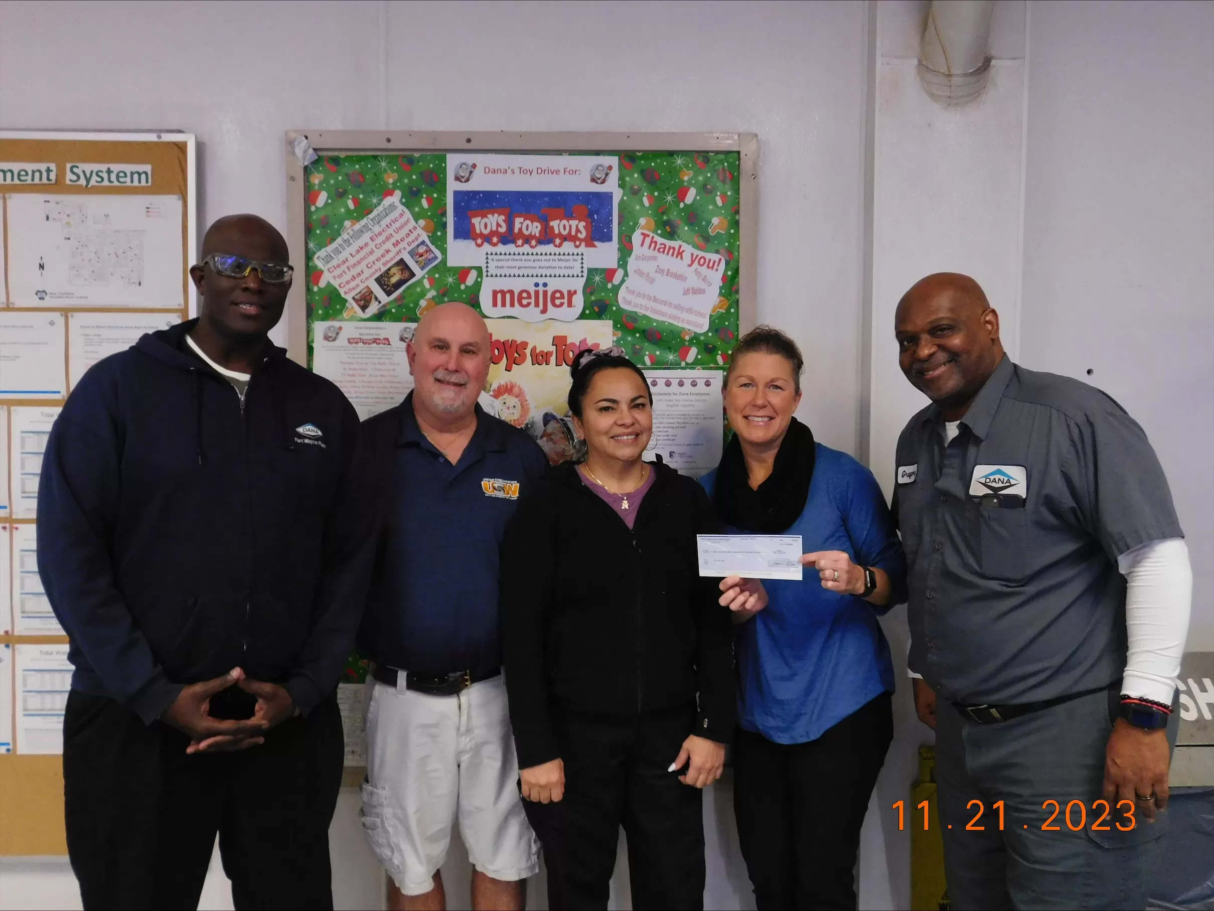 Jessica Menor presents $2,100 check to Dana Corp. employees for annual holiday toy drive