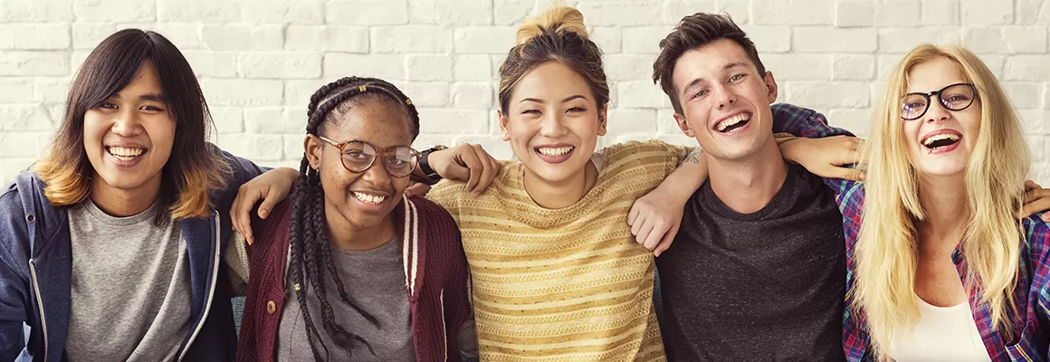 diverse group of students against a white brick wall