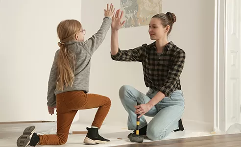 mom and daughter high-fiving after completing flooring project